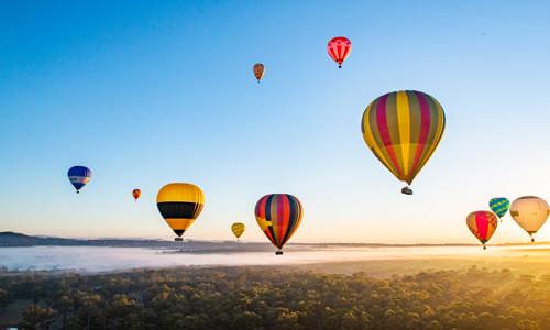 Landscape view of hot air balloons in sky