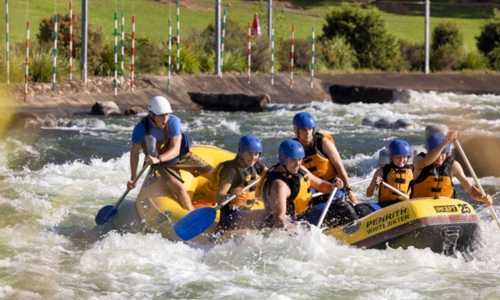 Group of people rafting as part of a team building activity at Penrith Whitewater Stadium