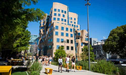 Students walk past the Chau Chak Wing Building at UTS on a sunny day