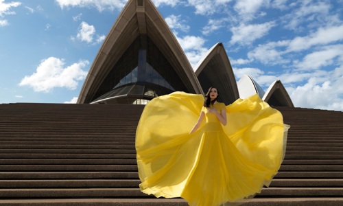 A performer in yellow dress at the steps of the Sydney Opera House 